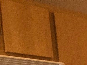 an empty kitchen with wooden floors and a refrigerator
